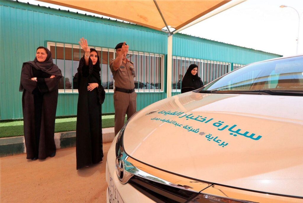 Drei Frauen an einer saudischen Fahrschule vor einem Auto nach der Aufhebung des Fahrverbots für Frauen.